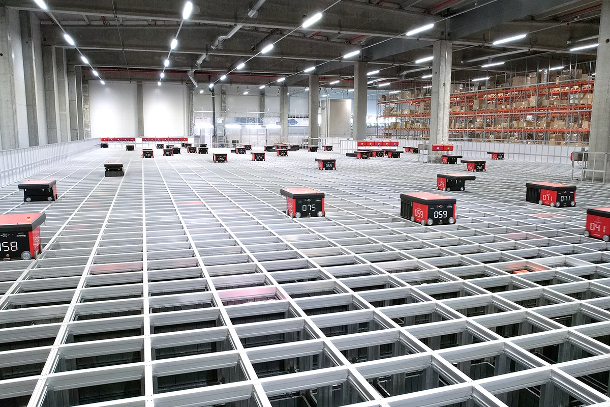 Automatisoitu varastojärjestelmä keräilyrobotteineen logistiikkakeskuksessa.